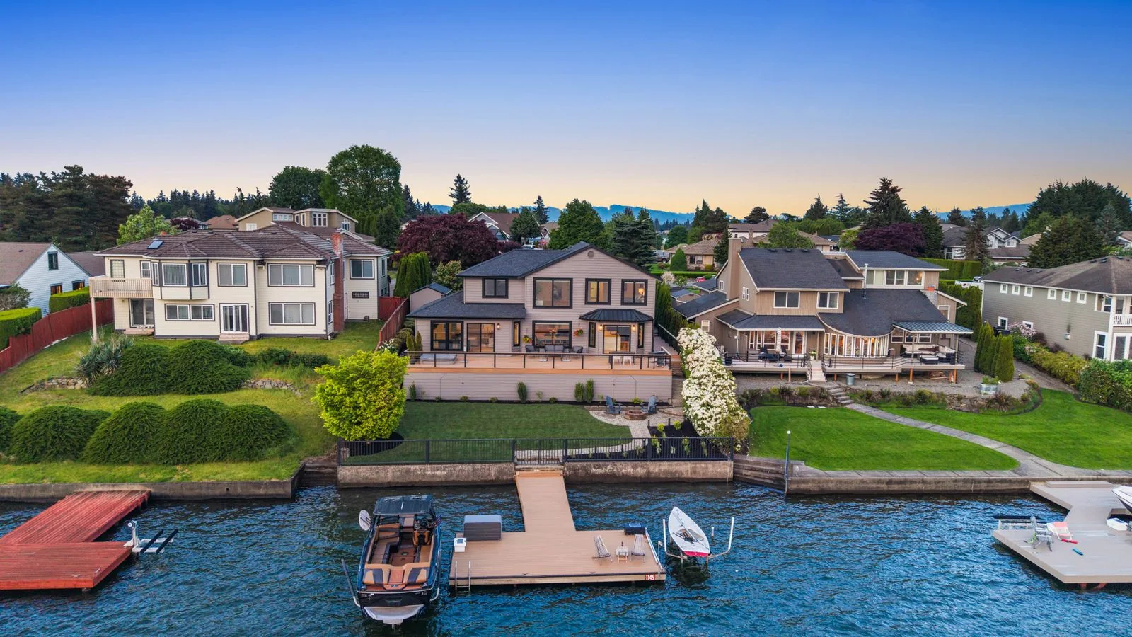 Aerial view of waterfront homes and private docks at sunset