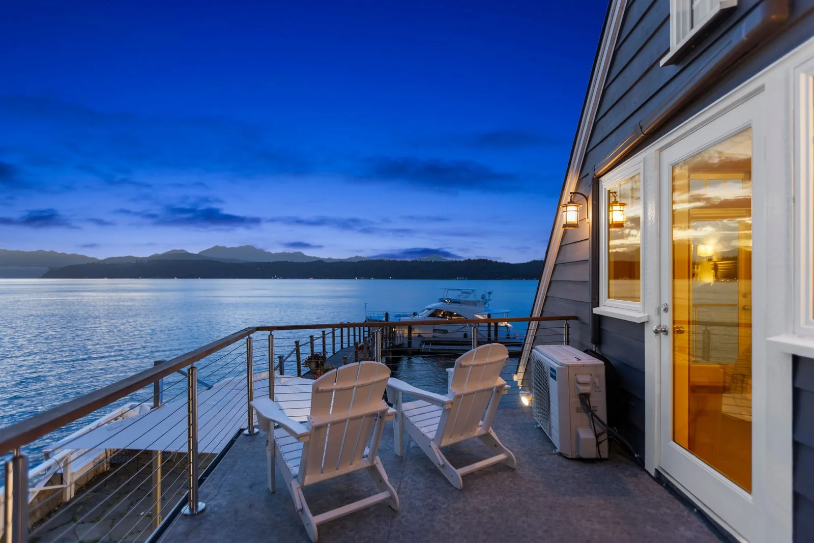 Waterfront deck at blue hour with an illuminated interior